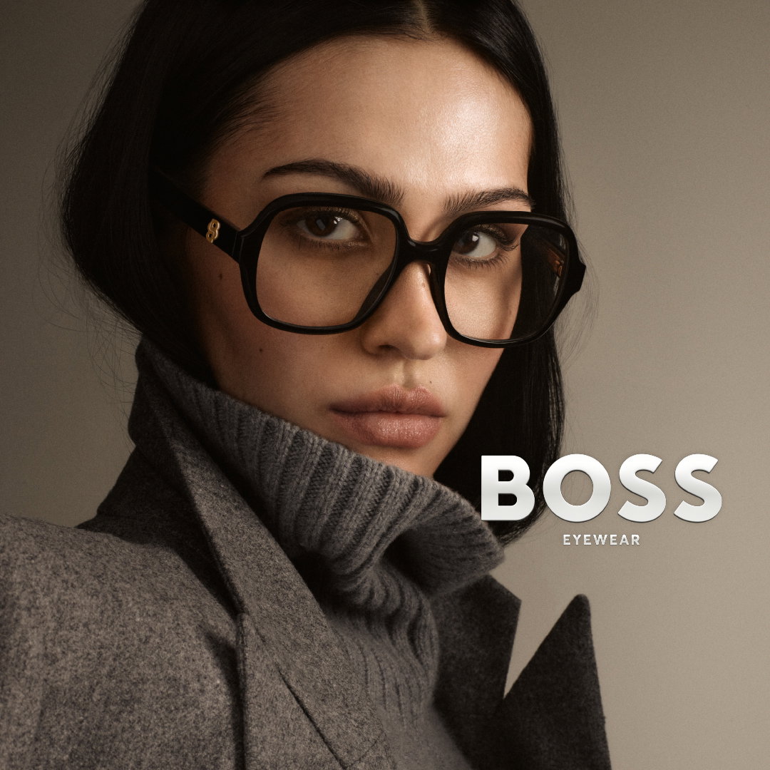 Das Bild zeigt eine Frau mit Brille und Rollkragen. Im Vordergrund ist das BOSS Logo zu sehen.